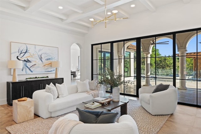 living room featuring beam ceiling, a wealth of natural light, and a chandelier