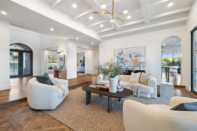 living room with a notable chandelier, beam ceiling, and coffered ceiling