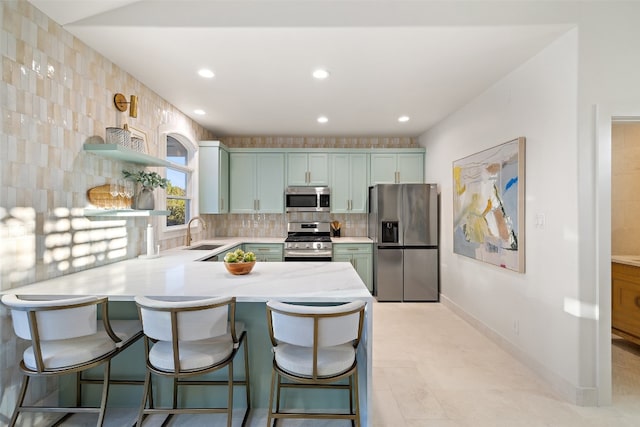 kitchen with kitchen peninsula, a breakfast bar, light tile patterned flooring, sink, and stainless steel appliances