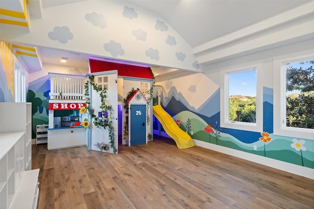 playroom with lofted ceiling and light wood-type flooring