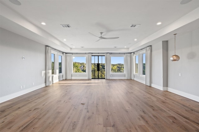 unfurnished living room with light hardwood / wood-style flooring, ceiling fan, and a wealth of natural light