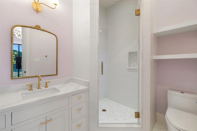 bathroom featuring a shower with door, vanity, and toilet