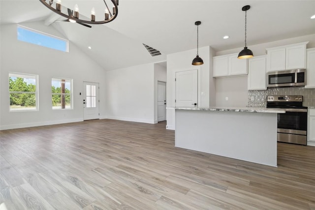 343 Cottle Town Rd Unit A, Smithville, TX 78957 - kitchen with stainless steel appliances, high vaulted ceiling, decorative backsplash, white cabinetry, and a chandelier