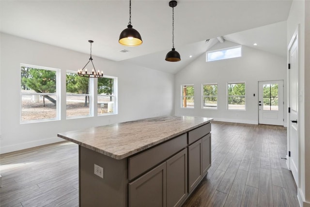 343 Cottle Town Rd Unit A, Smithville, TX 78957 - kitchen featuring gray cabinetry, open floor plan, wood finished floors, a kitchen island, and decorative light fixtures