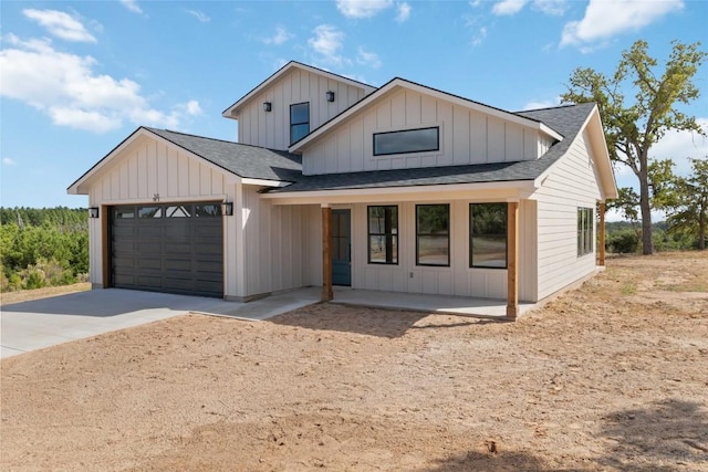 343 Cottle Town Rd Unit A, Smithville, TX 78957 - modern farmhouse featuring roof with shingles, concrete driveway, an attached garage, board and batten siding, and a porch