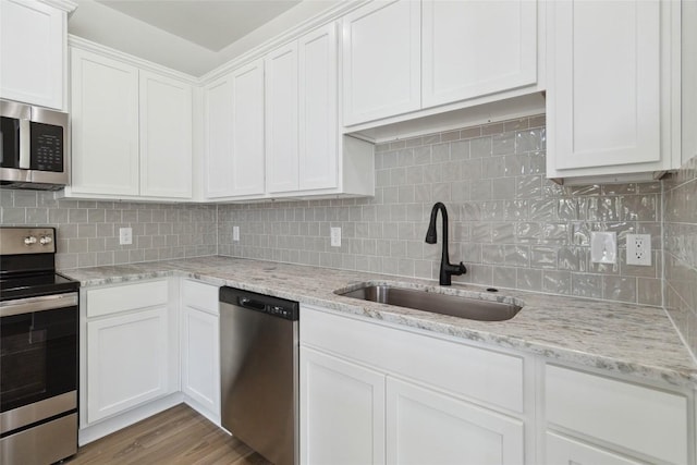 343 Cottle Town Rd Unit A, Smithville, TX 78957 - kitchen featuring stainless steel appliances, white cabinets, tasteful backsplash, and light stone countertops
