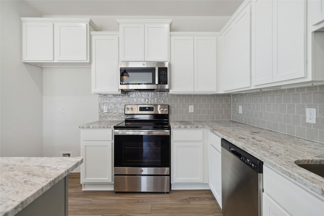 kitchen with white cabinetry, appliances with stainless steel finishes, decorative backsplash, and dark wood-type flooring