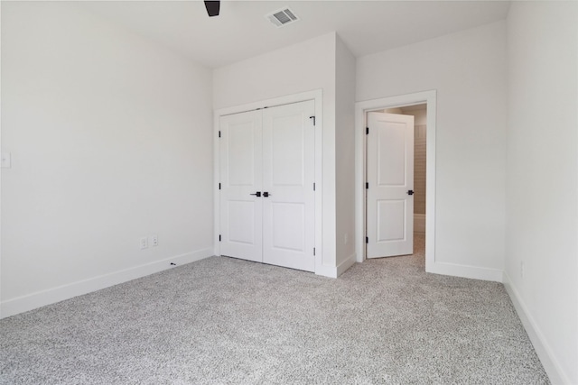 unfurnished bedroom with a closet, light colored carpet, and ceiling fan