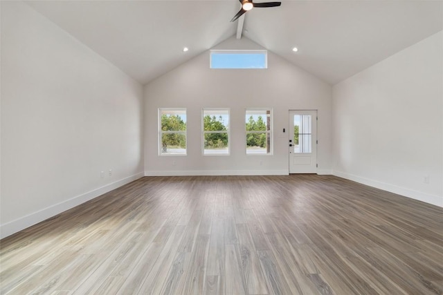 343 Cottle Town Rd Unit A, Smithville, TX 78957 - unfurnished living room featuring ceiling fan, plenty of natural light, wood finished floors, high vaulted ceiling, and beam ceiling