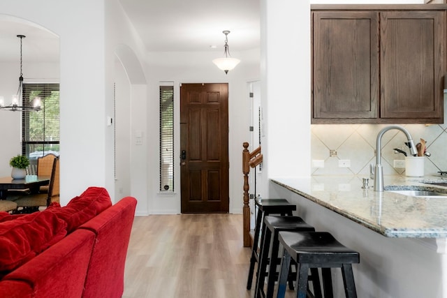 interior space with a chandelier, light wood-type flooring, and sink