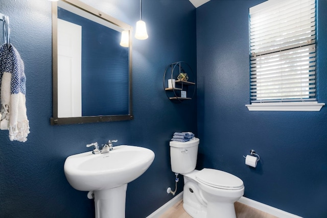 bathroom with hardwood / wood-style floors, toilet, and sink