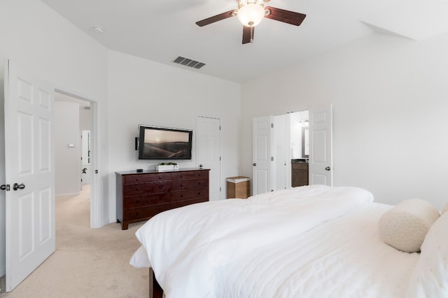 bedroom featuring connected bathroom, ceiling fan, and light carpet