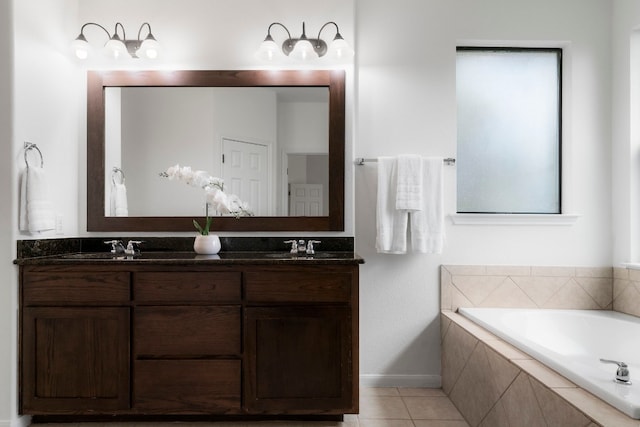 bathroom featuring tile patterned floors, tiled bath, and vanity