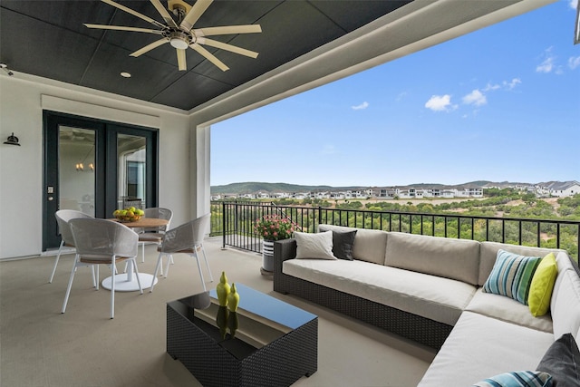 balcony with a mountain view, ceiling fan, and an outdoor hangout area