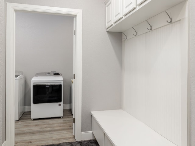 mudroom with light hardwood / wood-style floors and separate washer and dryer