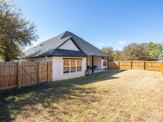 rear view of property with a yard and a patio area