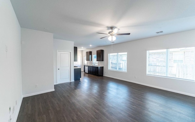 unfurnished living room with ceiling fan, sink, and dark wood-type flooring