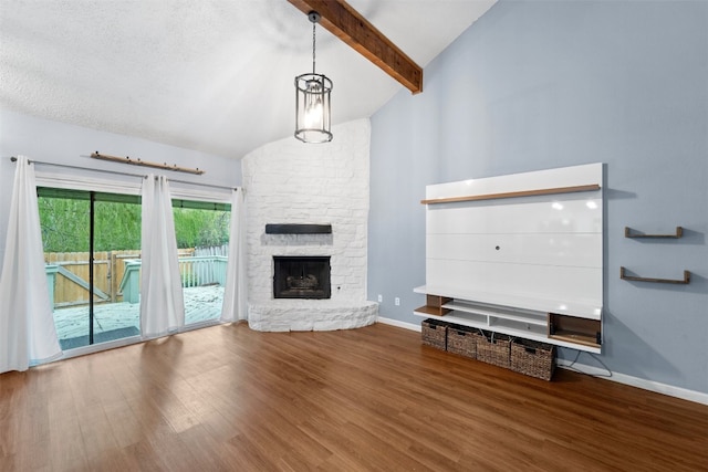 unfurnished living room with a stone fireplace, a textured ceiling, hardwood / wood-style floors, beam ceiling, and high vaulted ceiling