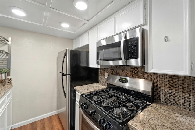 kitchen featuring backsplash, appliances with stainless steel finishes, and white cabinetry