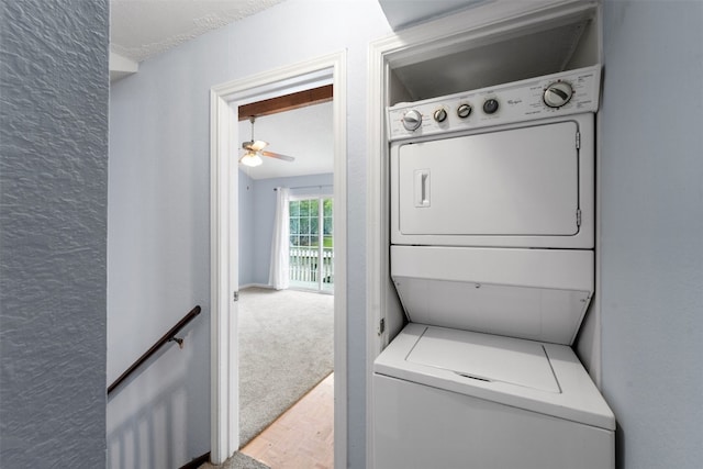 clothes washing area featuring stacked washer / dryer, carpet, and ceiling fan