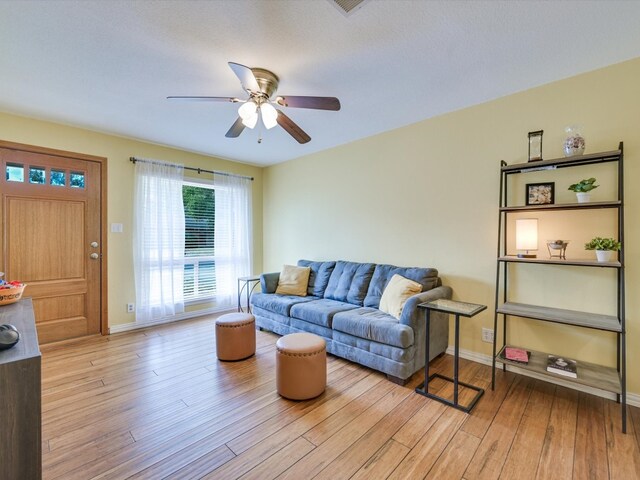 living room with ceiling fan and light wood-type flooring