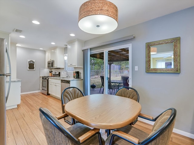 dining room featuring sink and light hardwood / wood-style floors