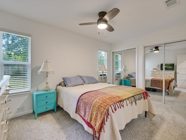 bedroom with multiple closets, carpet flooring, and ceiling fan