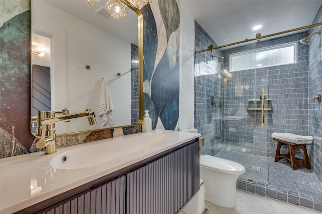 bathroom featuring a tile shower, vanity, and toilet