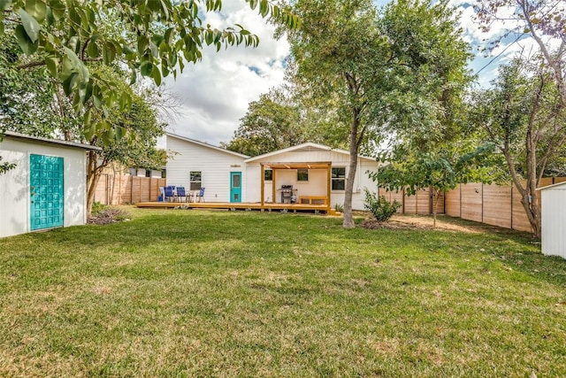 back of house with a yard, a deck, and a shed