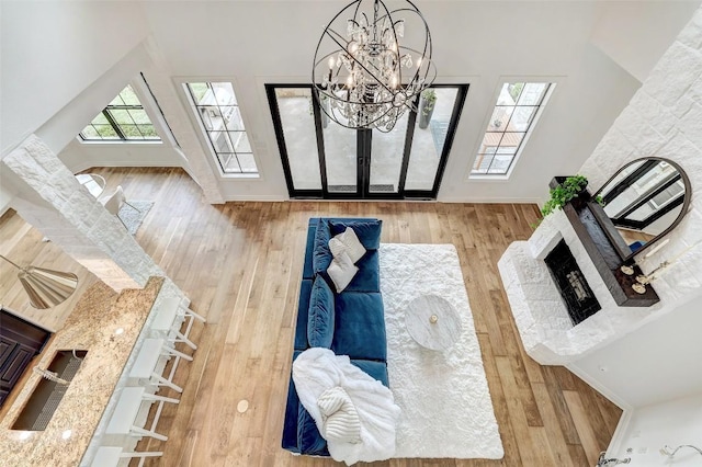 15006 Nightingale Ln, Austin, TX 78734 - living room featuring wood finished floors, a chandelier, a fireplace with raised hearth, and vaulted ceiling
