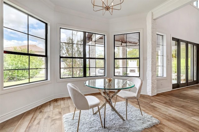 dining area featuring ornamental molding, a wealth of natural light, hardwood / wood-style floors, and an inviting chandelier