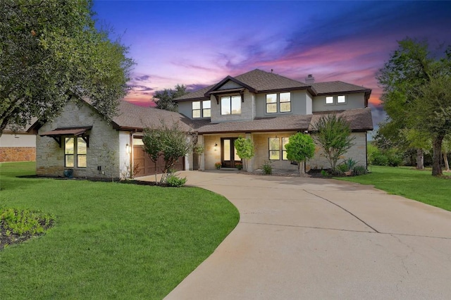 view of front of house with a garage and a yard