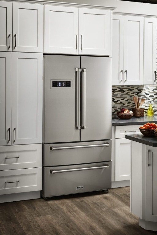 kitchen featuring backsplash, white cabinetry, high quality fridge, and dark wood-type flooring