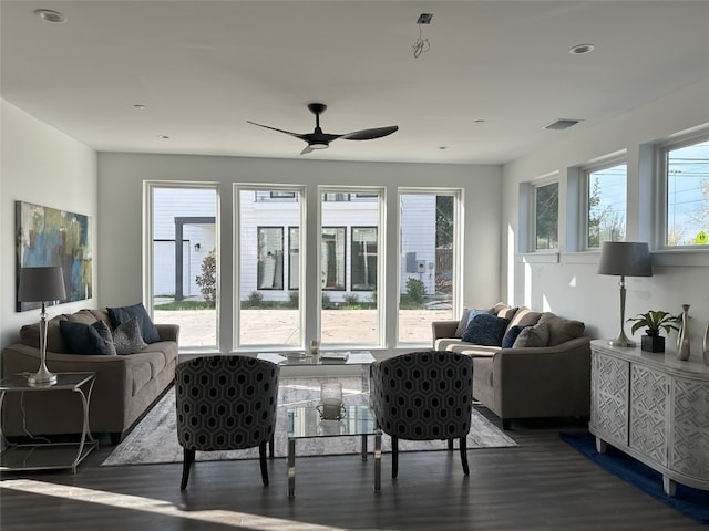 living room with ceiling fan and dark wood-type flooring