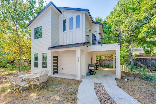 rear view of house with a patio, a balcony, and a carport