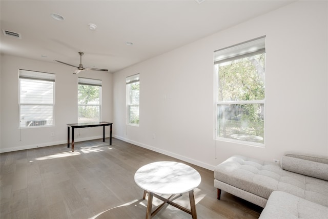 living area featuring hardwood / wood-style floors and ceiling fan