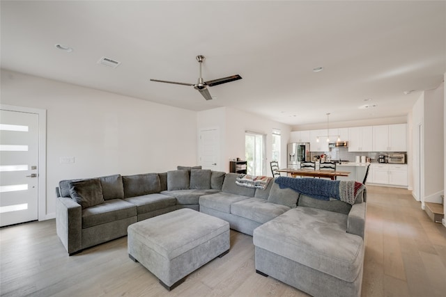 living room featuring ceiling fan and light wood-type flooring