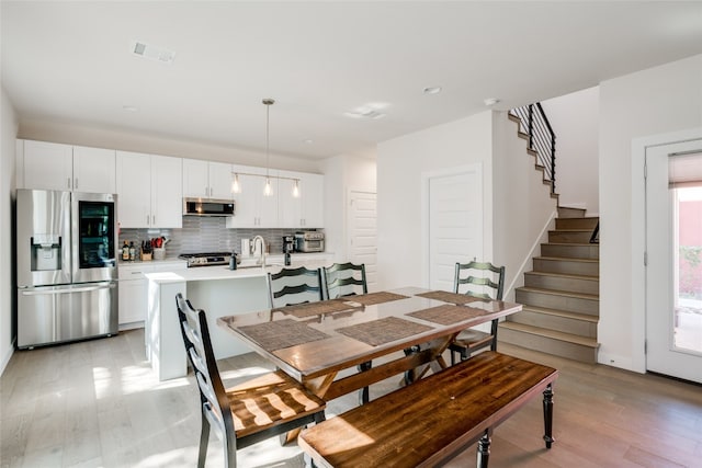 dining area featuring sink and light hardwood / wood-style flooring