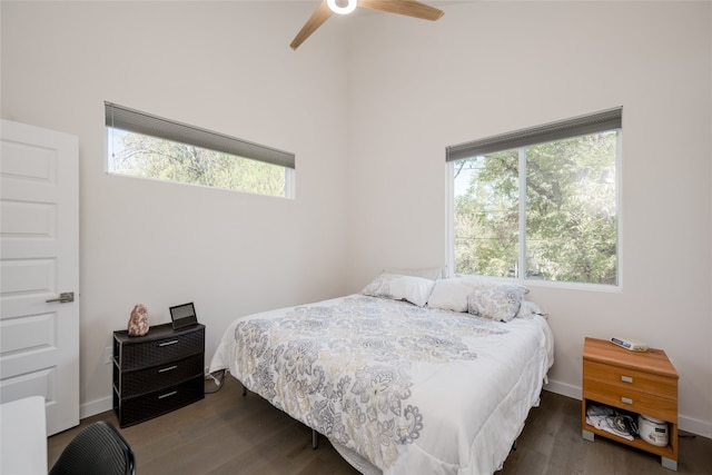 bedroom featuring dark hardwood / wood-style flooring, multiple windows, and ceiling fan