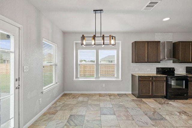 kitchen with dark brown cabinets, black range with electric cooktop, wall chimney exhaust hood, a chandelier, and tasteful backsplash