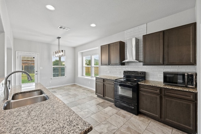 kitchen with black electric range, a notable chandelier, hanging light fixtures, wall chimney exhaust hood, and sink