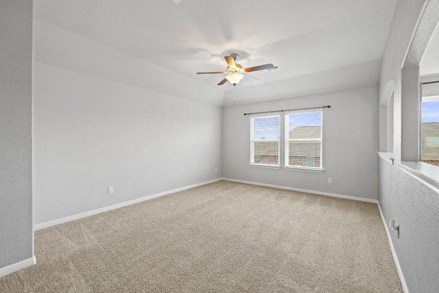 carpeted spare room featuring ceiling fan and vaulted ceiling