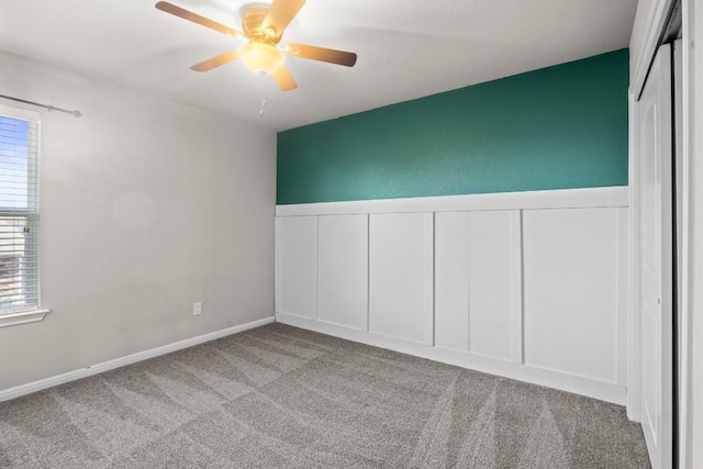 424 Hendelson Ln, Hutto, TX 78634 - carpeted empty room featuring a ceiling fan, a decorative wall, and a wainscoted wall
