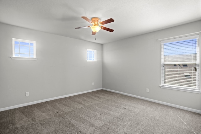 spare room with carpet, a healthy amount of sunlight, and ceiling fan