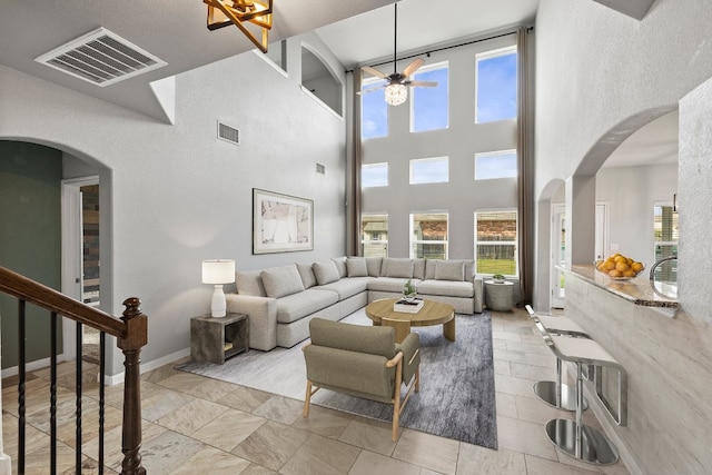 living room featuring ceiling fan and a high ceiling