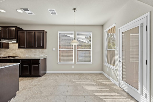 kitchen featuring decorative backsplash, dark brown cabinetry, decorative light fixtures, and light tile patterned floors