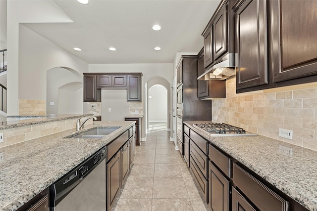 kitchen featuring light stone countertops, sink, appliances with stainless steel finishes, and backsplash