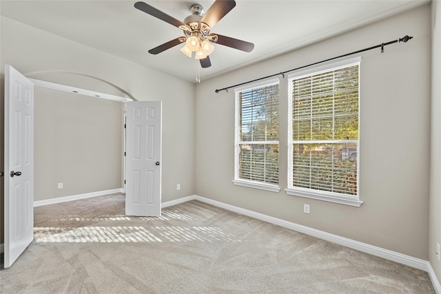 empty room featuring light colored carpet and ceiling fan