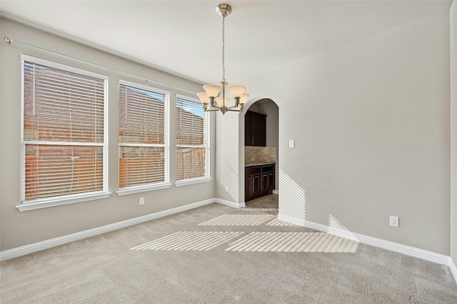 unfurnished dining area with light carpet and an inviting chandelier