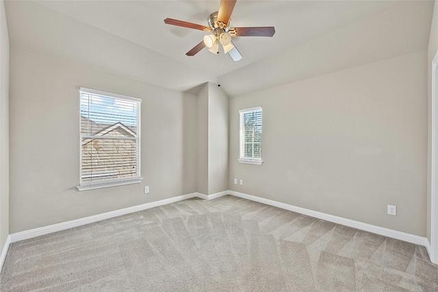 spare room featuring light carpet, lofted ceiling, and ceiling fan